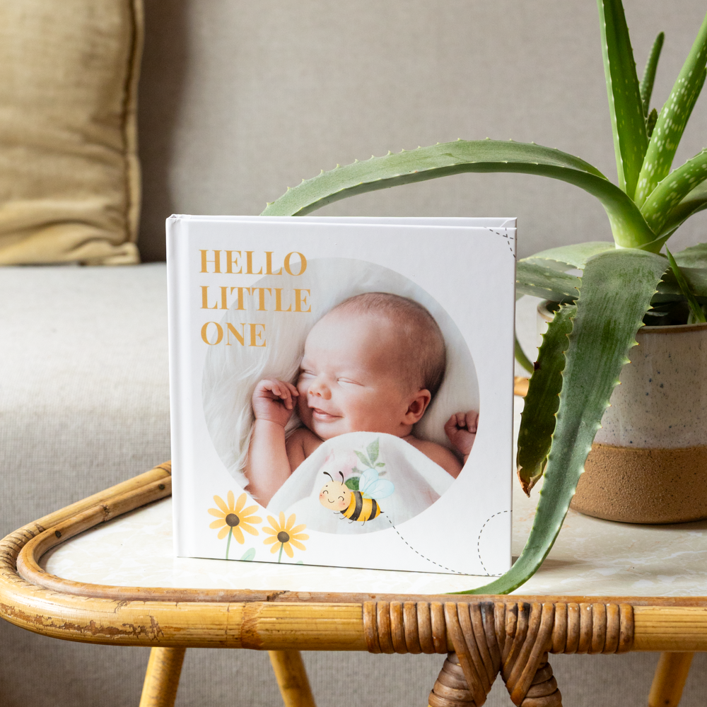 Vlakliggend fotoboek wit met baby op tafel Vlakliggend fotoboek wit met baby op tafel